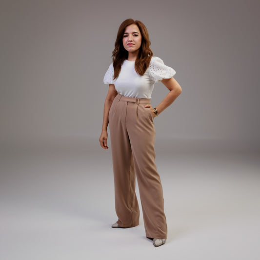 woman wearing white eyelet sleeve tshirt with tan wide leg pants